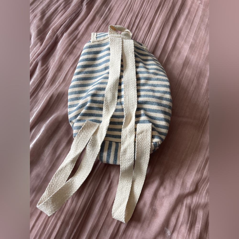 Striped blue and cream backpack with small zip pocket in front. - Picture 2 of 6